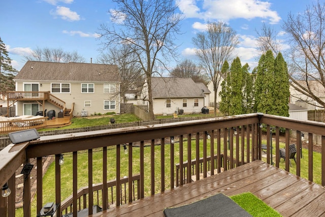 wooden deck featuring stairs, a fenced backyard, a lawn, and a residential view