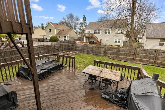 deck featuring a fenced backyard, outdoor dining space, a lawn, and a residential view