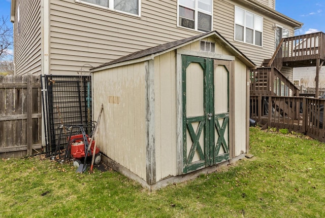 view of shed with stairway and a fenced backyard