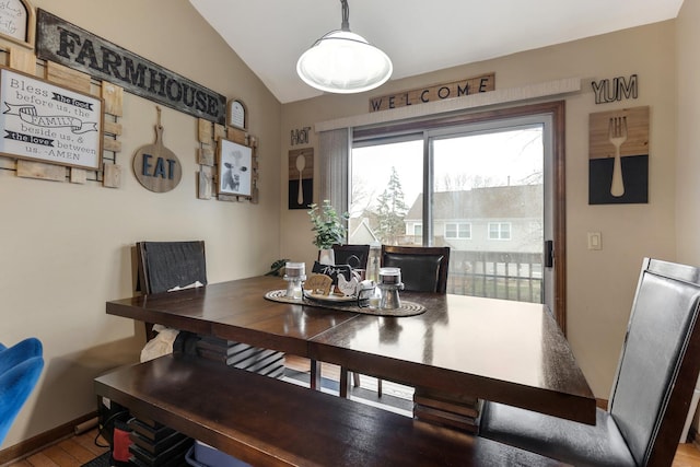 dining room with baseboards, lofted ceiling, and wood finished floors