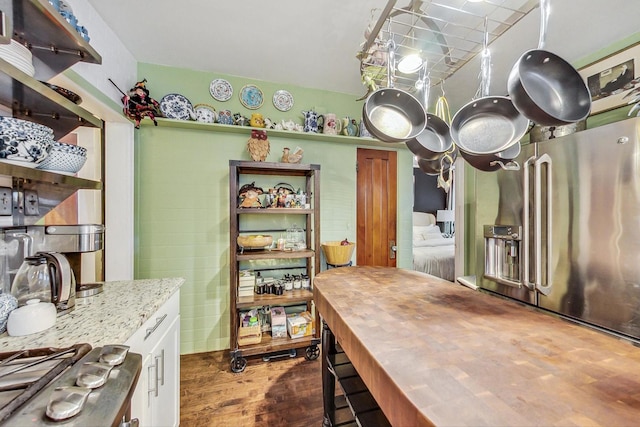 kitchen featuring stainless steel appliances, light stone counters, and dark wood finished floors