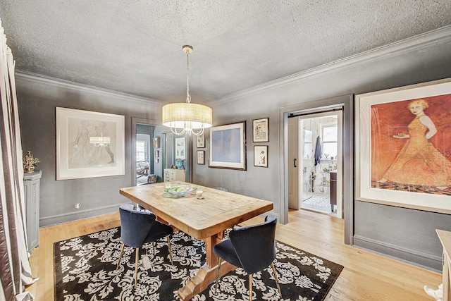 dining space with baseboards, a notable chandelier, light wood-style floors, a textured ceiling, and crown molding