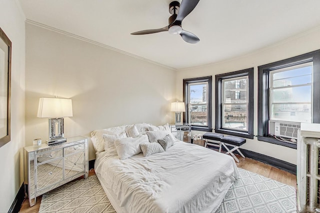 bedroom featuring multiple windows, light wood-type flooring, and ornamental molding