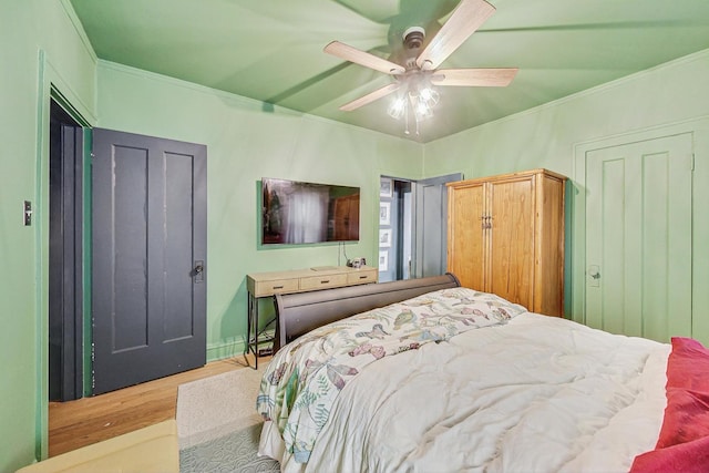 bedroom with crown molding, wood finished floors, and ceiling fan