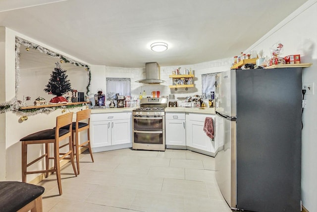 kitchen featuring wall chimney exhaust hood, open shelves, white cabinets, appliances with stainless steel finishes, and light countertops