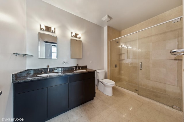 bathroom featuring toilet, double vanity, a sink, and a shower stall