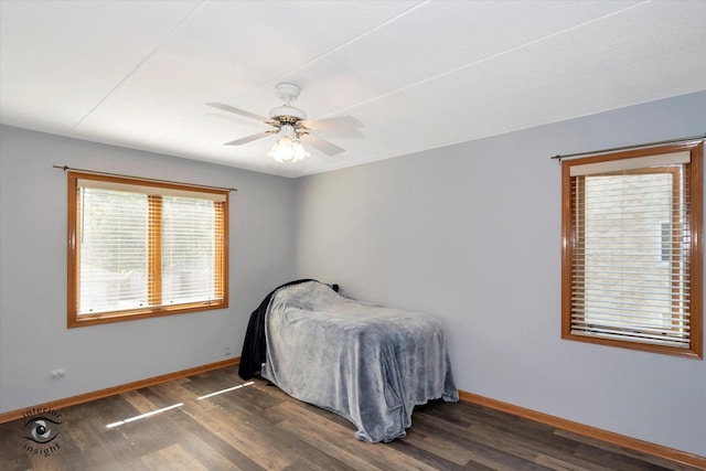 bedroom with baseboards, a ceiling fan, visible vents, and wood finished floors