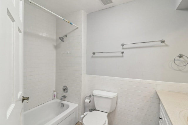 bathroom with visible vents, toilet, bathtub / shower combination, vanity, and wainscoting