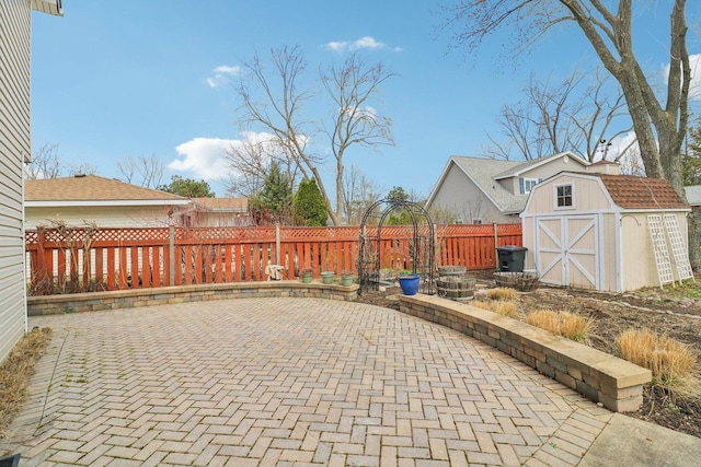 view of patio with a storage shed, a fenced backyard, and an outdoor structure