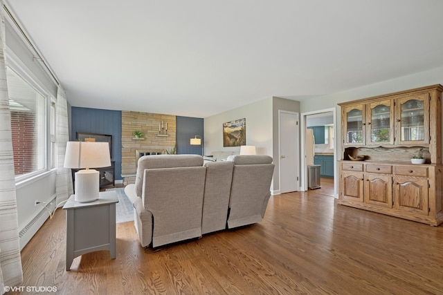 1112 N Perry Dr, Palatine, IL 60067 - living room with a baseboard heating unit, wood finished floors, a stone fireplace, and baseboards