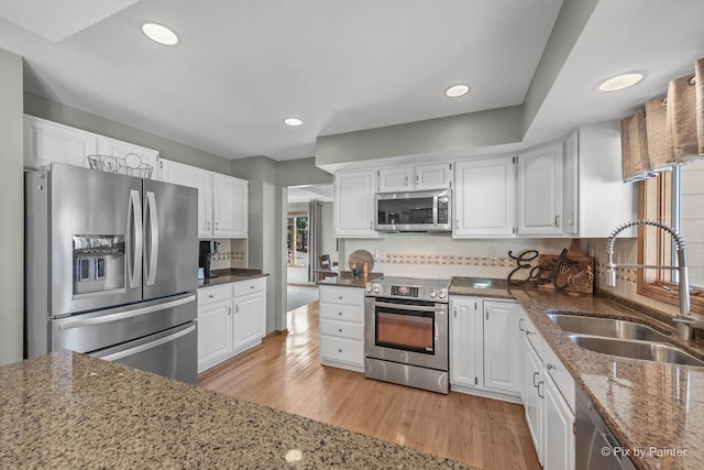 kitchen featuring a sink, white cabinets, and stainless steel appliances