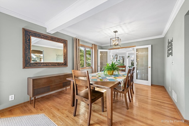 dining room with crown molding, baseboards, light wood finished floors, and a chandelier