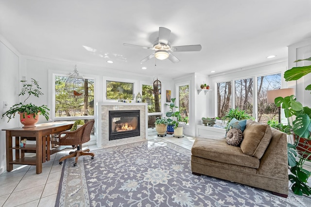 living area featuring a tiled fireplace, light tile patterned flooring, ceiling fan, and recessed lighting