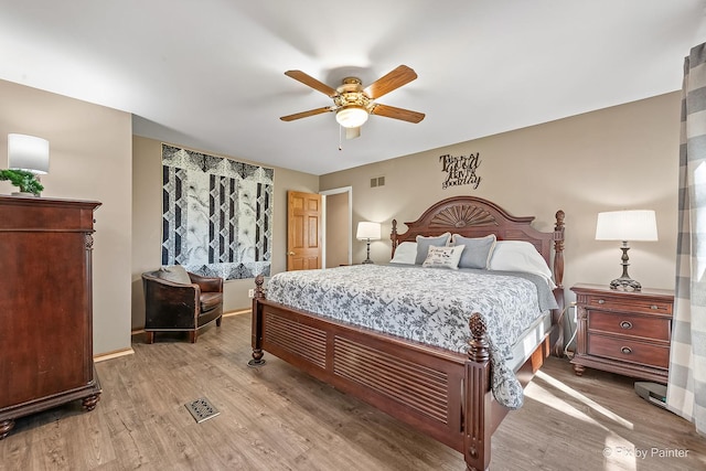 bedroom featuring visible vents, baseboards, a ceiling fan, and wood finished floors