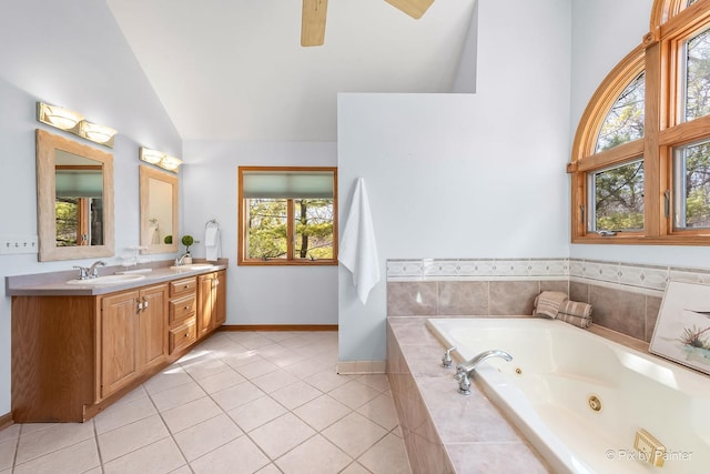 full bath with a sink, double vanity, a jetted tub, vaulted ceiling, and tile patterned floors