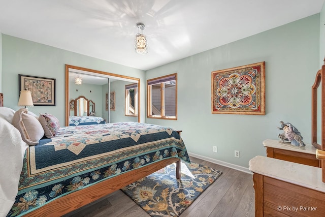bedroom with a closet, baseboards, and wood finished floors