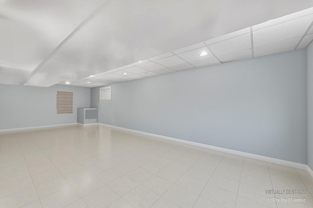 empty room with recessed lighting, baseboards, light tile patterned flooring, and a drop ceiling