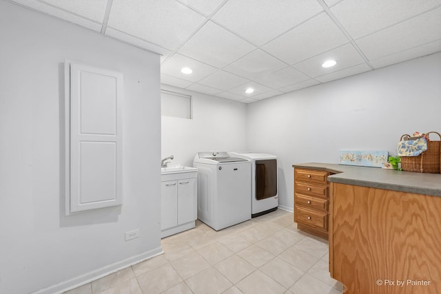 clothes washing area featuring baseboards, recessed lighting, cabinet space, washer and dryer, and a sink