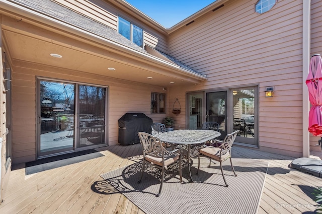 deck with outdoor dining area and grilling area