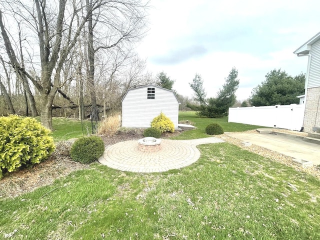view of yard featuring an outbuilding, a patio area, fence, and a storage shed