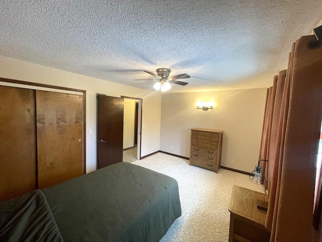 bedroom featuring baseboards, light carpet, a ceiling fan, and a textured ceiling
