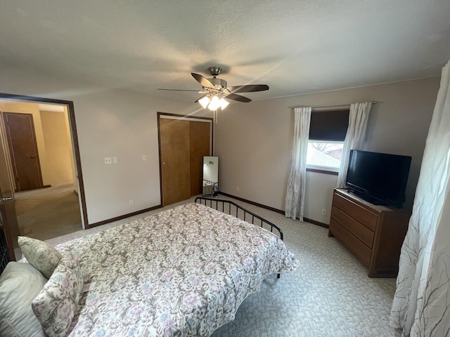 bedroom with a closet, baseboards, light carpet, and a ceiling fan