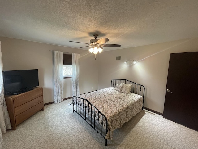 bedroom featuring ceiling fan, light carpet, a textured ceiling, baseboards, and visible vents