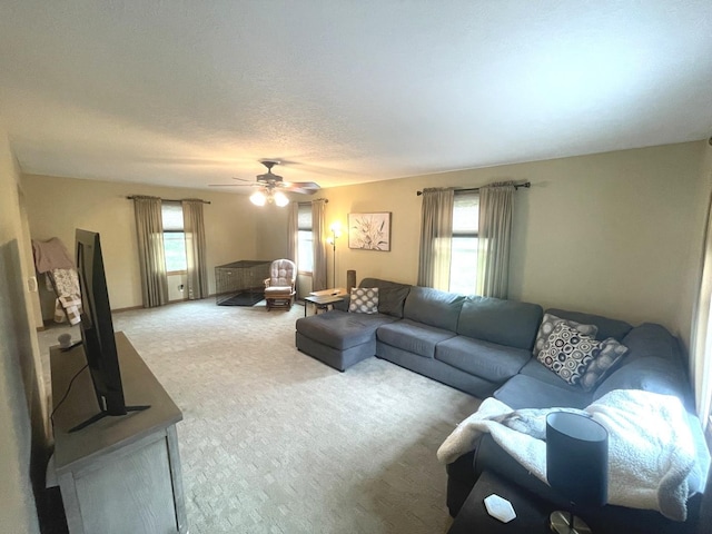 carpeted living area featuring a ceiling fan