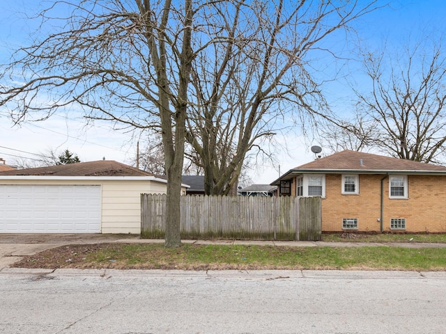 view of side of home featuring brick siding and fence