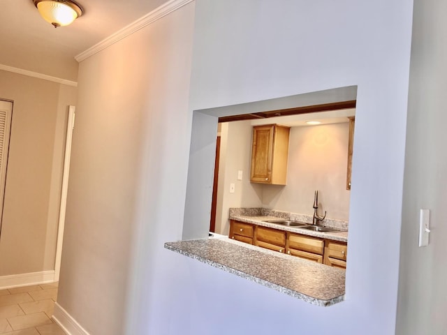 5424 W Ferdinand St Unit 104, Chicago, IL 60644 - kitchen with crown molding, light tile patterned flooring, light countertops, a sink, and baseboards