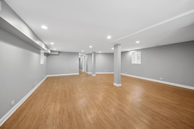 below grade area with light wood-type flooring, baseboards, and recessed lighting
