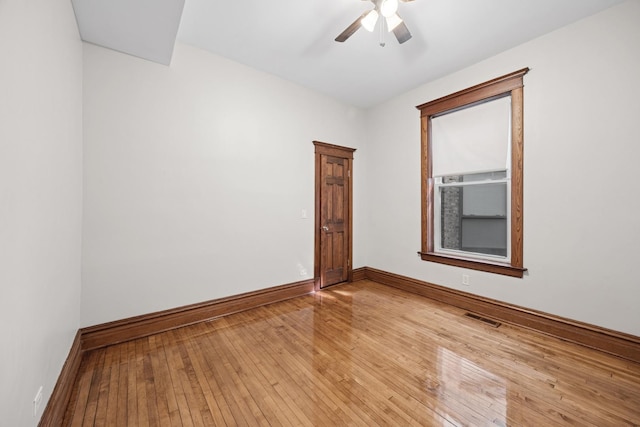 unfurnished room featuring baseboards, visible vents, light wood-type flooring, and a ceiling fan