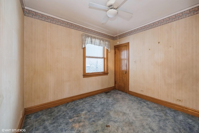 carpeted spare room with baseboards and a ceiling fan