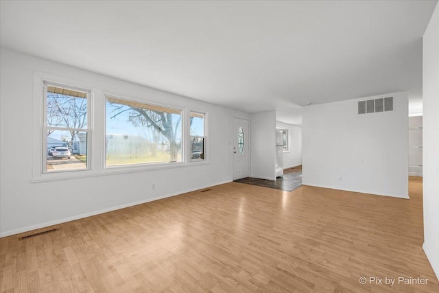 128 Adobe Cir, Carpentersville, IL 60110 - unfurnished living room featuring wood finished floors, baseboards, and visible vents