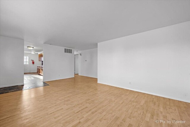 128 Adobe Cir, Carpentersville, IL 60110 - unfurnished living room with visible vents, baseboards, and wood finished floors