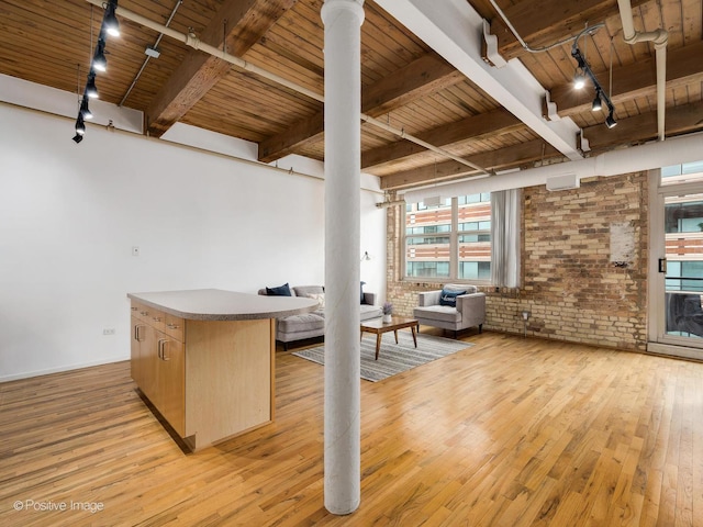kitchen with light wood-style floors, light brown cabinetry, wood ceiling, open floor plan, and brick wall