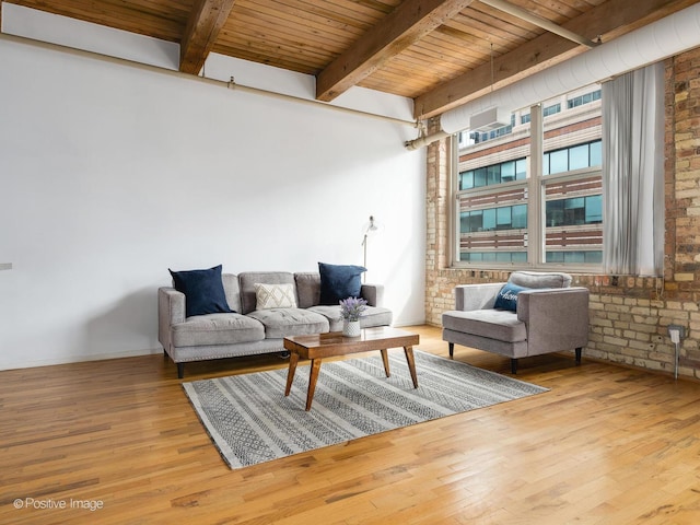 living area with brick wall, wood ceiling, beamed ceiling, and wood finished floors