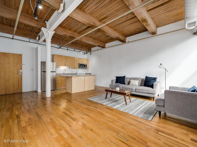 living area with beam ceiling, light wood-style flooring, and wooden ceiling