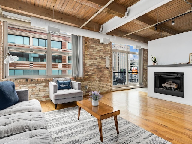 living area with wood finished floors, wooden ceiling, brick wall, and a fireplace