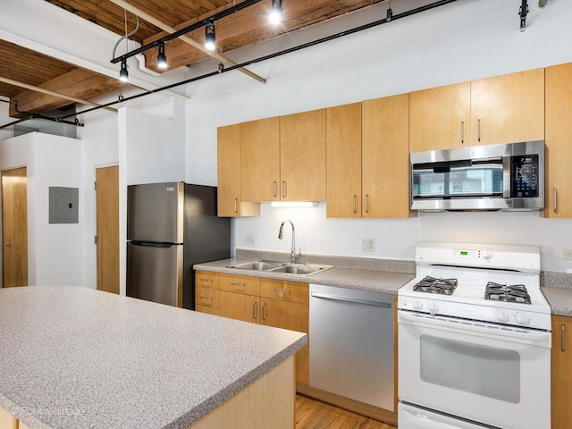 kitchen featuring track lighting, electric panel, light countertops, a sink, and stainless steel appliances