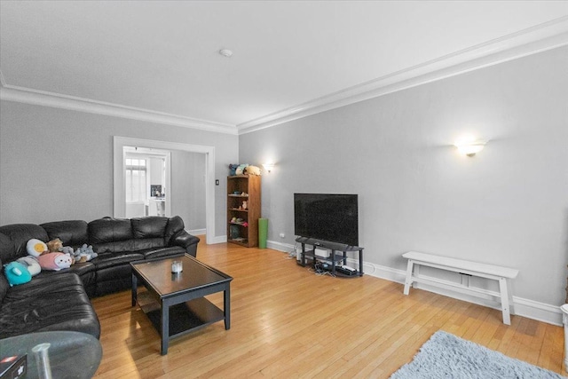 living room featuring baseboards, crown molding, and wood finished floors
