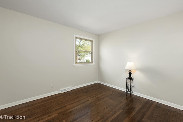empty room with baseboards and dark wood finished floors