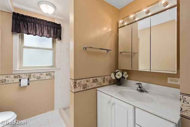 full bath featuring vanity, toilet, tiled shower, tile patterned floors, and tile walls