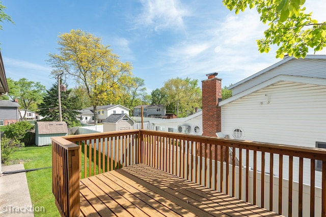 wooden terrace with a shed, an outbuilding, a residential view, and a fenced backyard