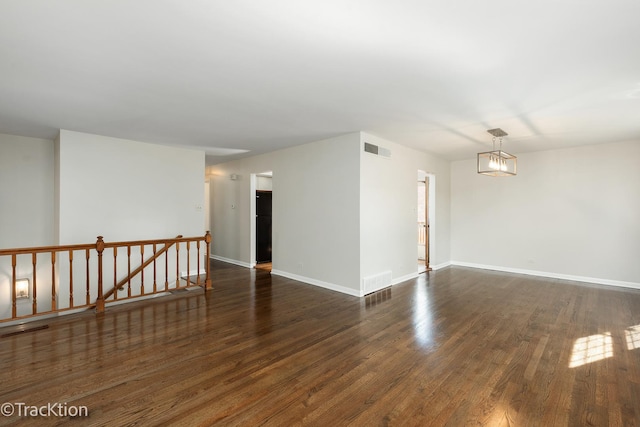 empty room with dark wood-style flooring and baseboards