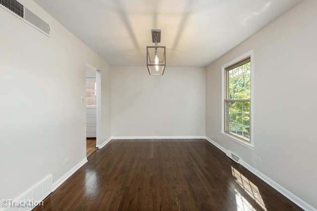 unfurnished dining area featuring dark wood finished floors and baseboards