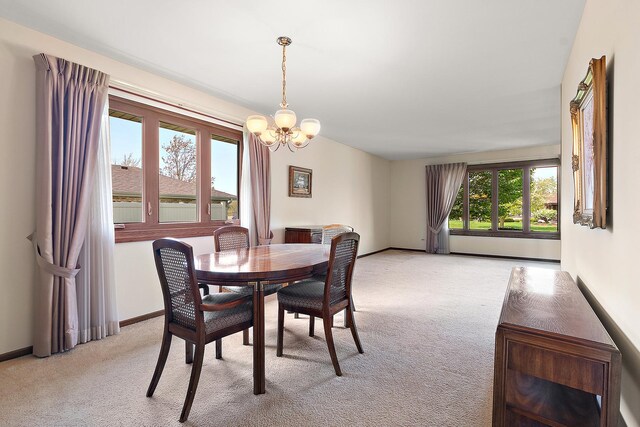 dining room featuring an inviting chandelier, baseboards, and light carpet