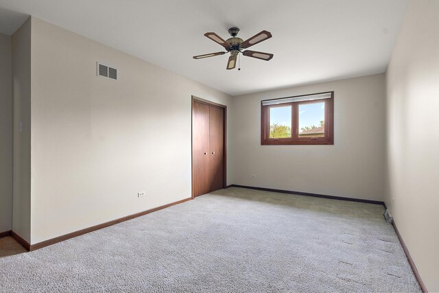 spare room with visible vents, baseboards, ceiling fan, and light colored carpet