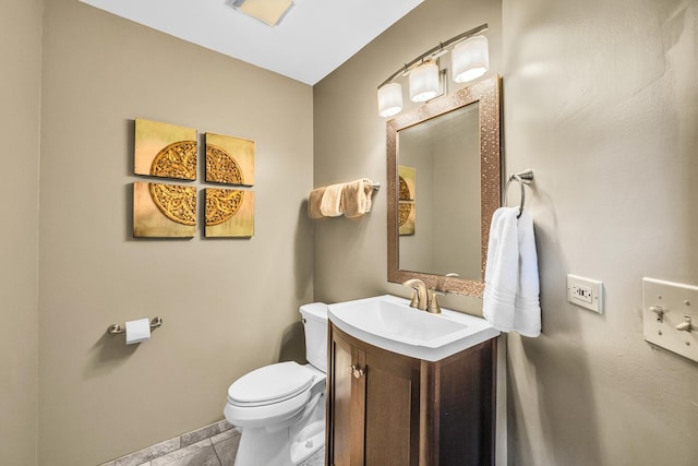 half bath featuring toilet, vanity, and baseboards