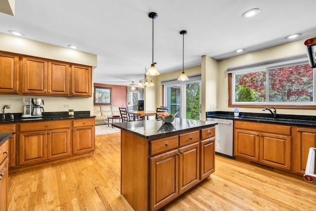 kitchen with stainless steel dishwasher, a sink, light wood-style flooring, brown cabinetry, and recessed lighting